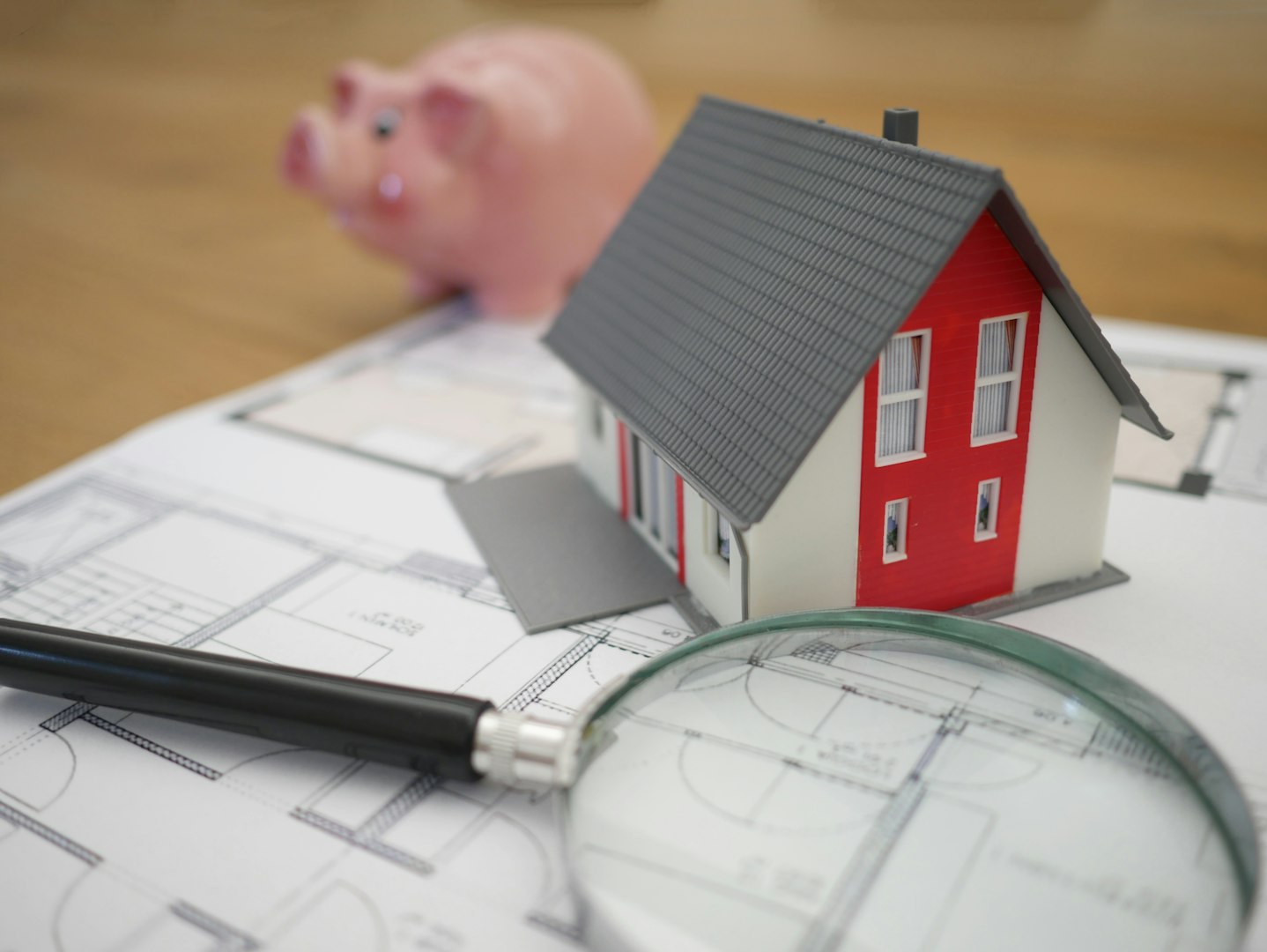 Model house and floor plans and piggy bank on table