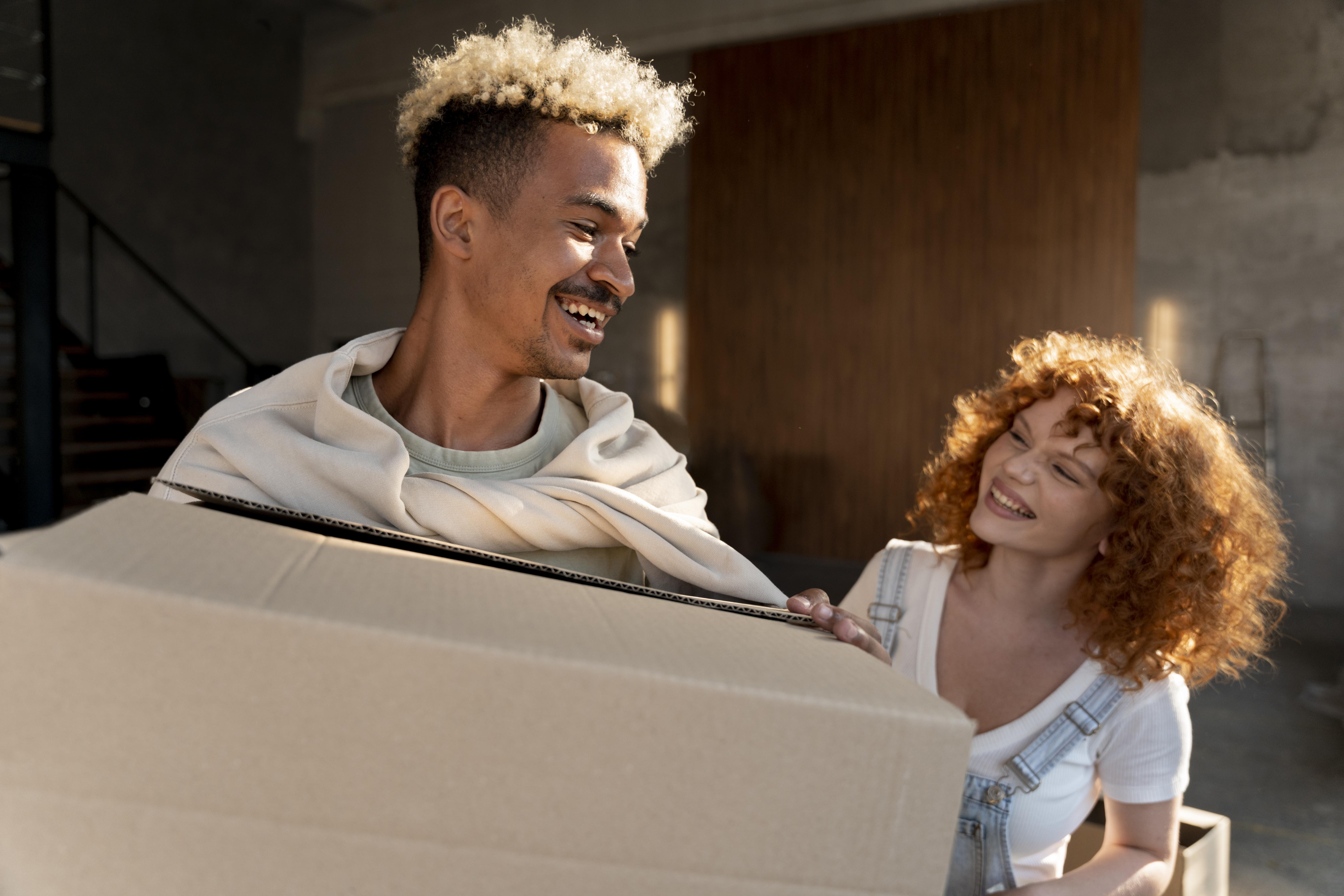 Happy Couple In There new home holding boxes