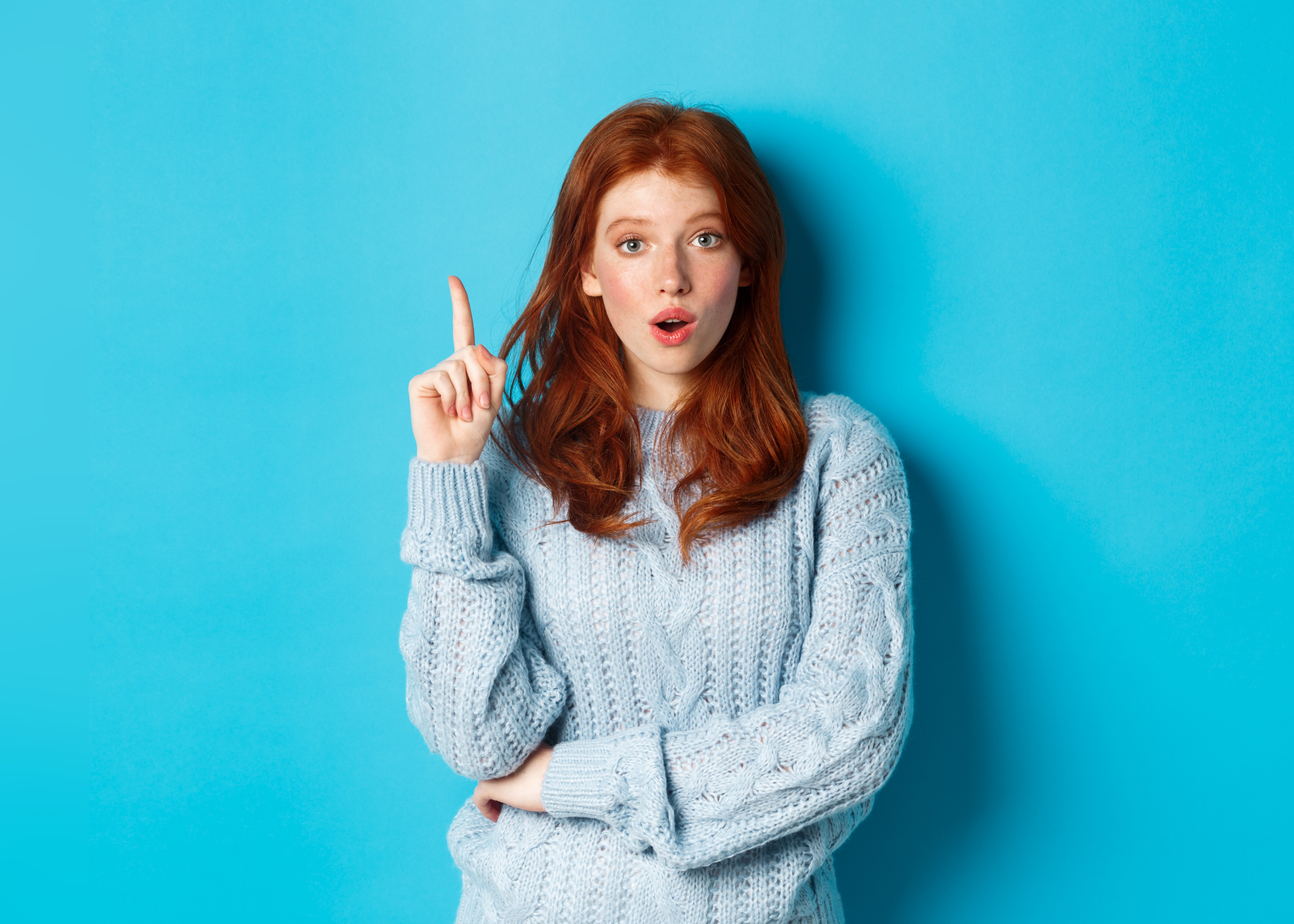 Thoughtful Red Haired Girl Raising Hand To Ask A Question