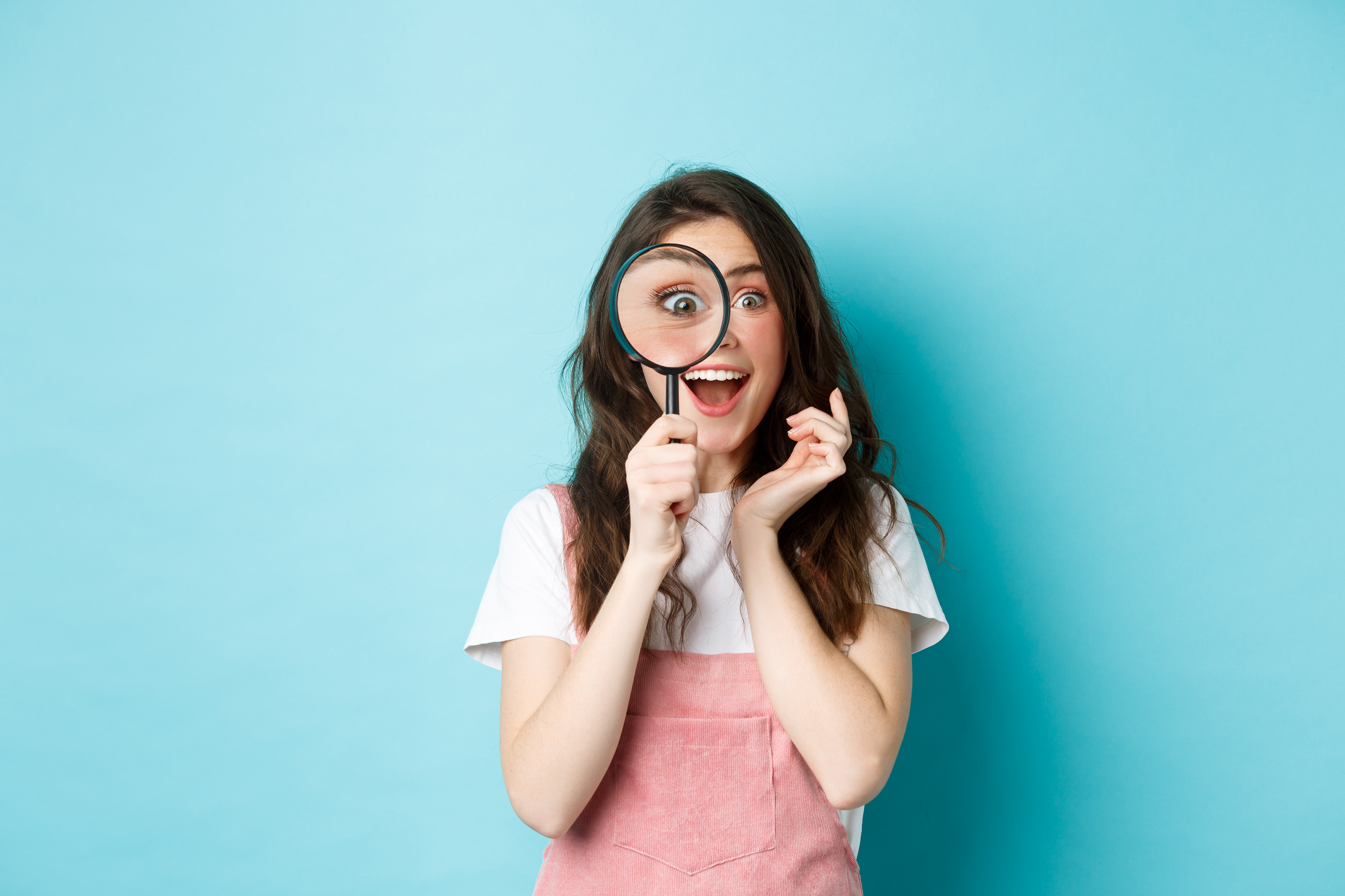 A women holding a magnified glass over her right eye