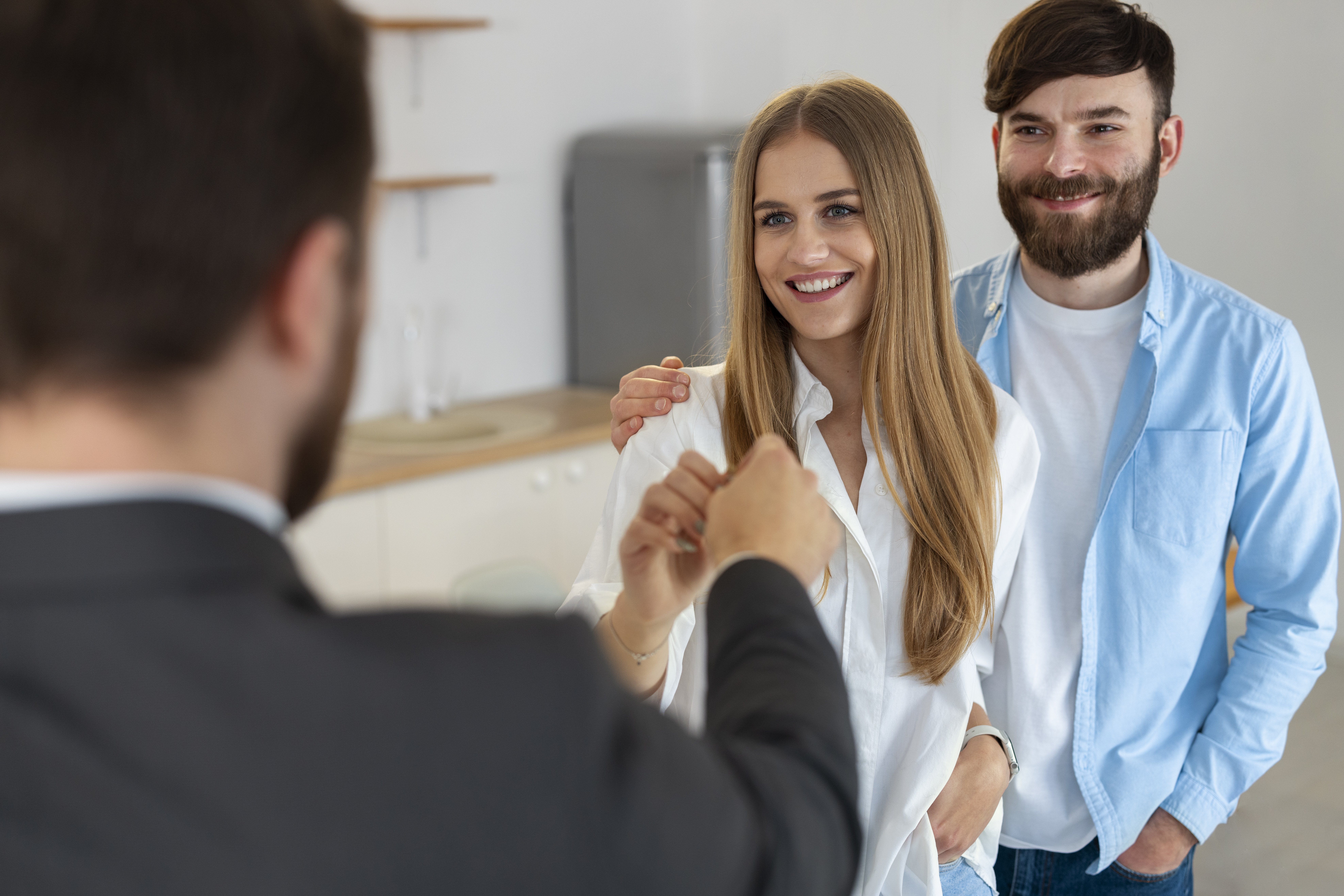 A Man passing a Women Holding keys To Her Home