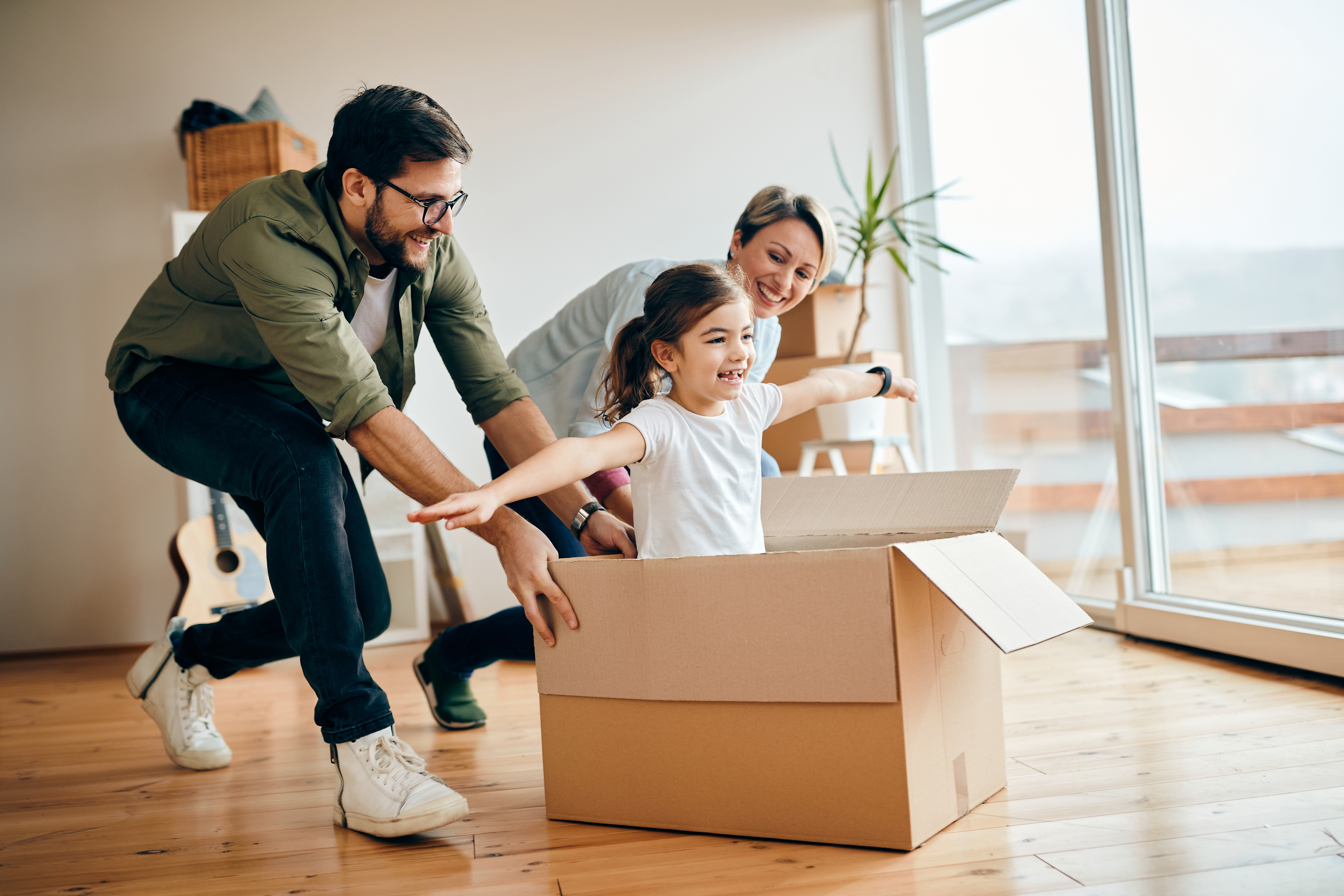 A Man pushing his daughter in a box in there new home