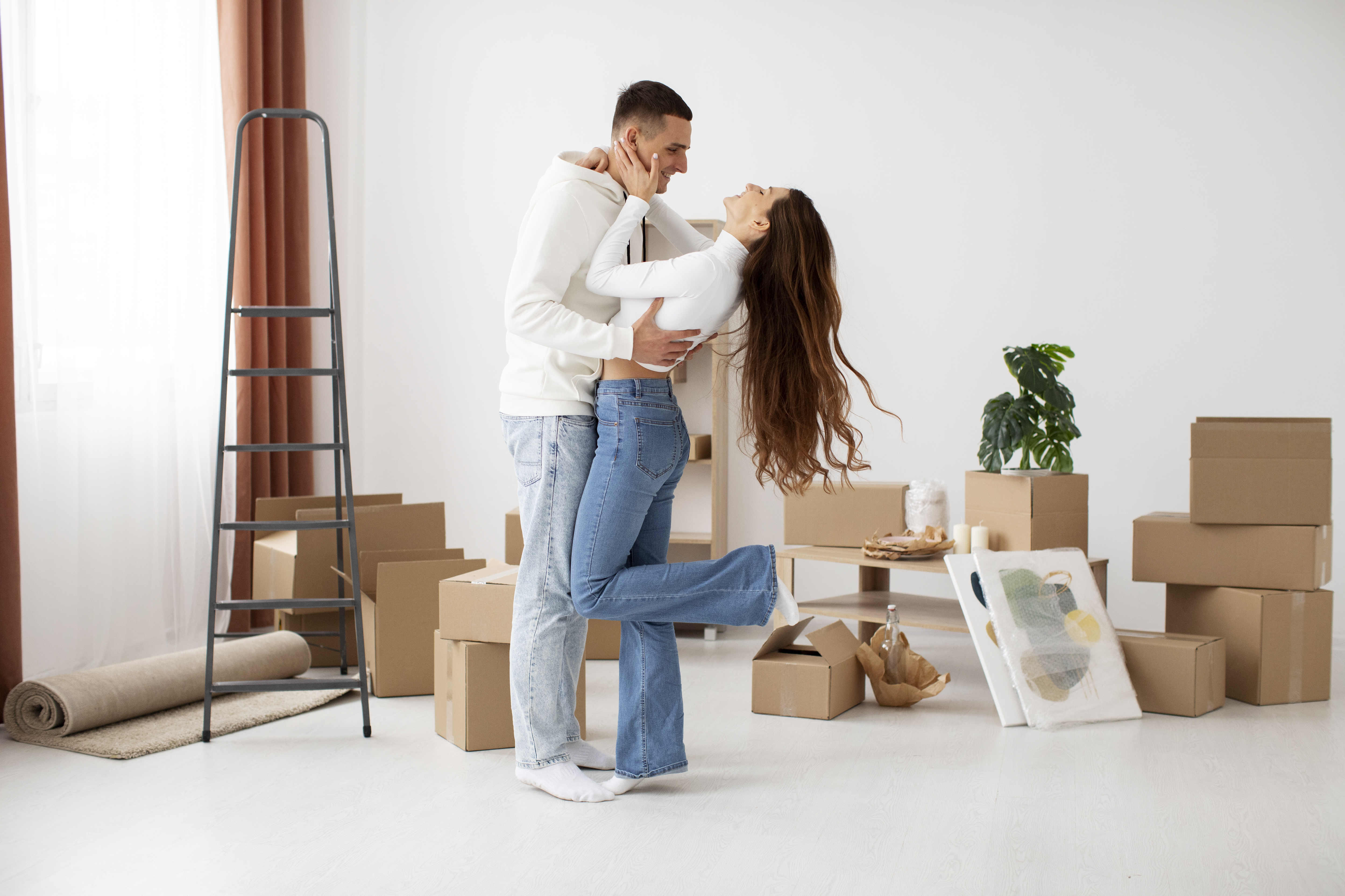 A man and women smiling. The women is holding the keys proudly in the new house