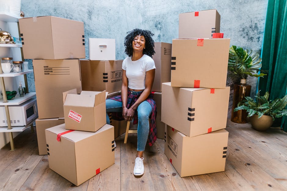 One happy women sitting in here new house surrounded by boxes