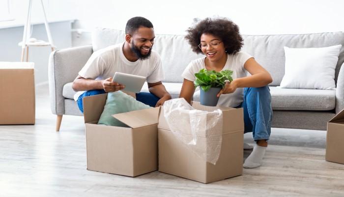 Mix race couple unpacking boxes in there new house